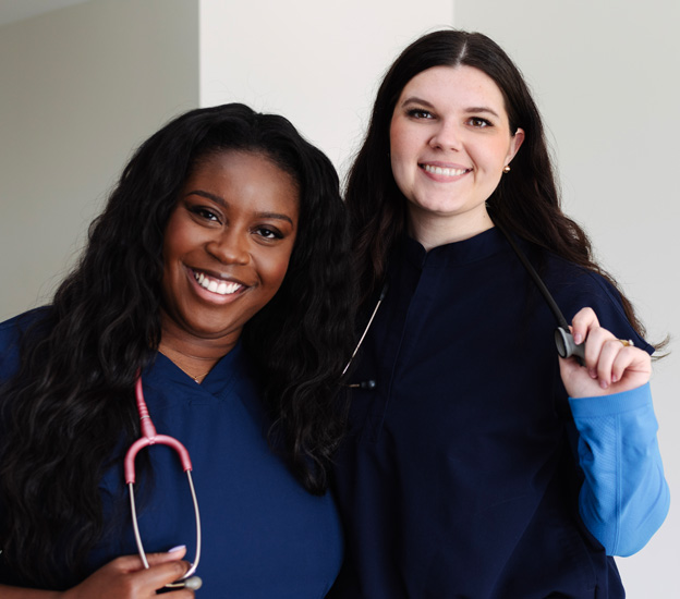 Two young female nurse smiling.
